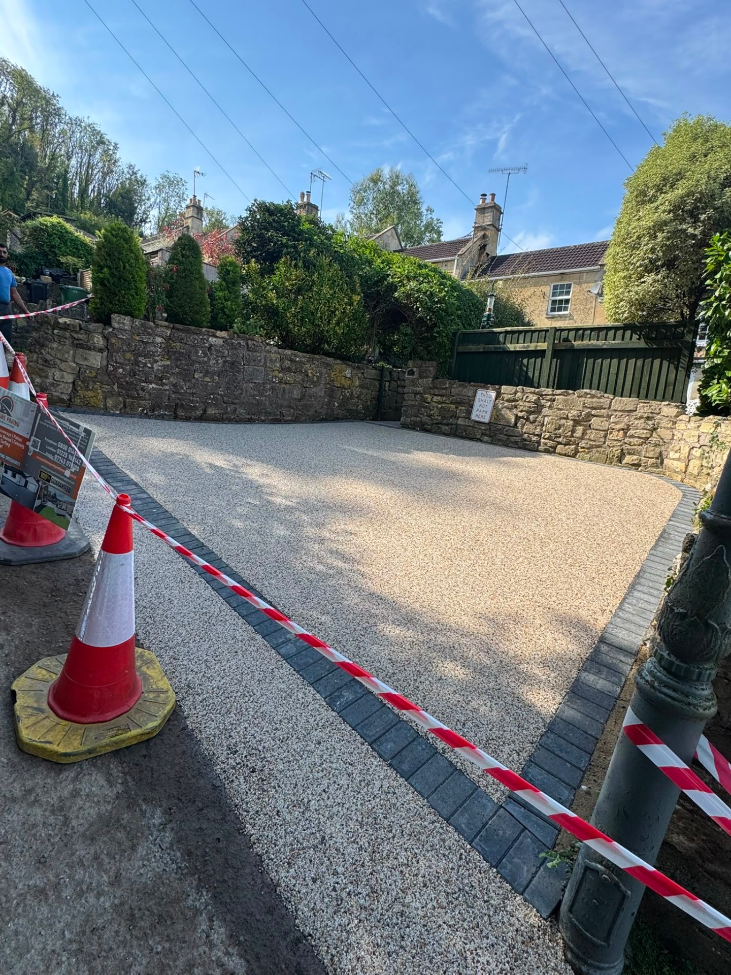 Wide gold resin bound driveway in front of stone cottages in Gloucester with sett border