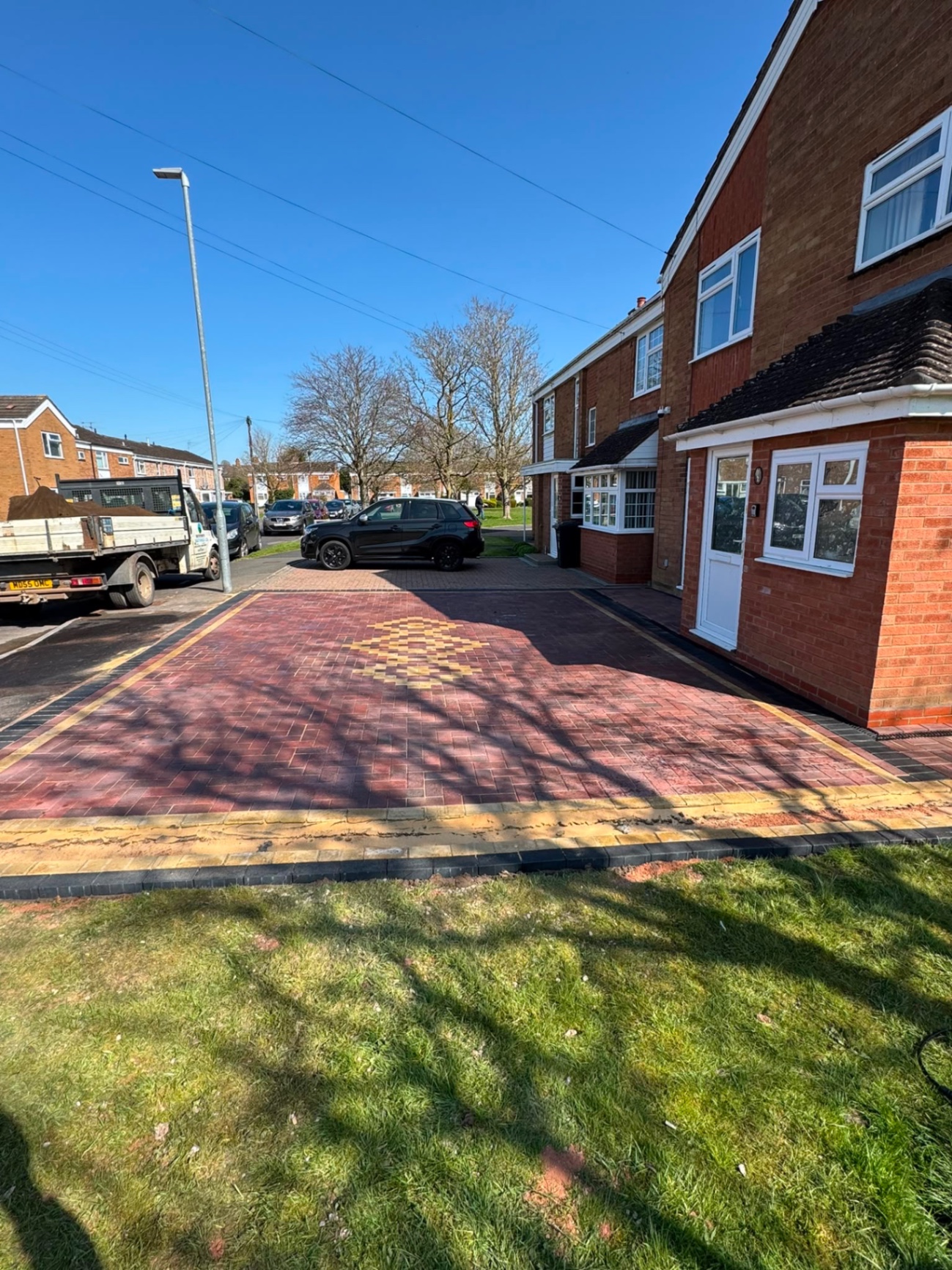 Red brindle block paving driveway with buff border and diamond feature in front of a Gloucester house