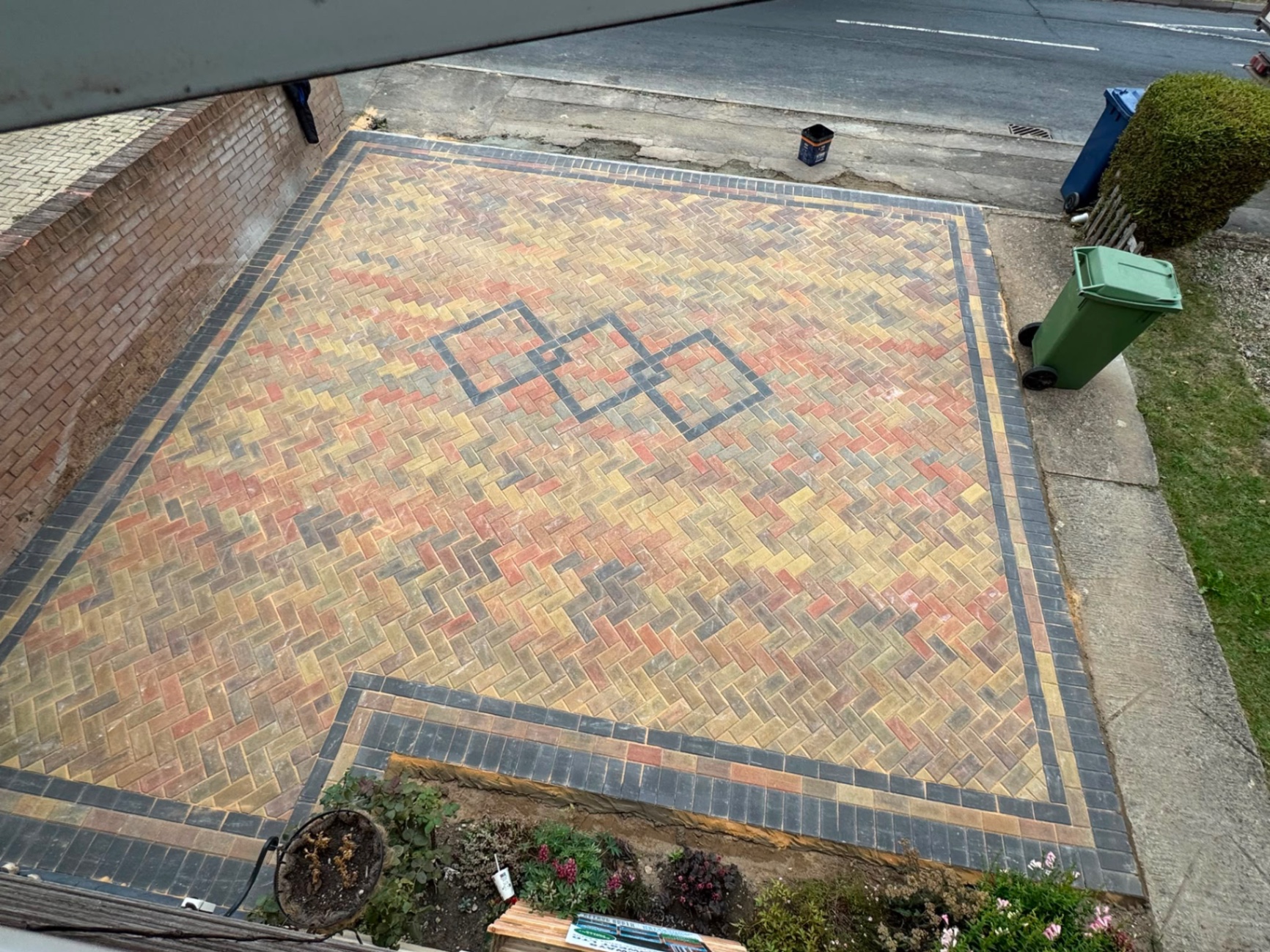 Overhead view of an autumn blend herringbone block driveway with charcoal border in Gloucester