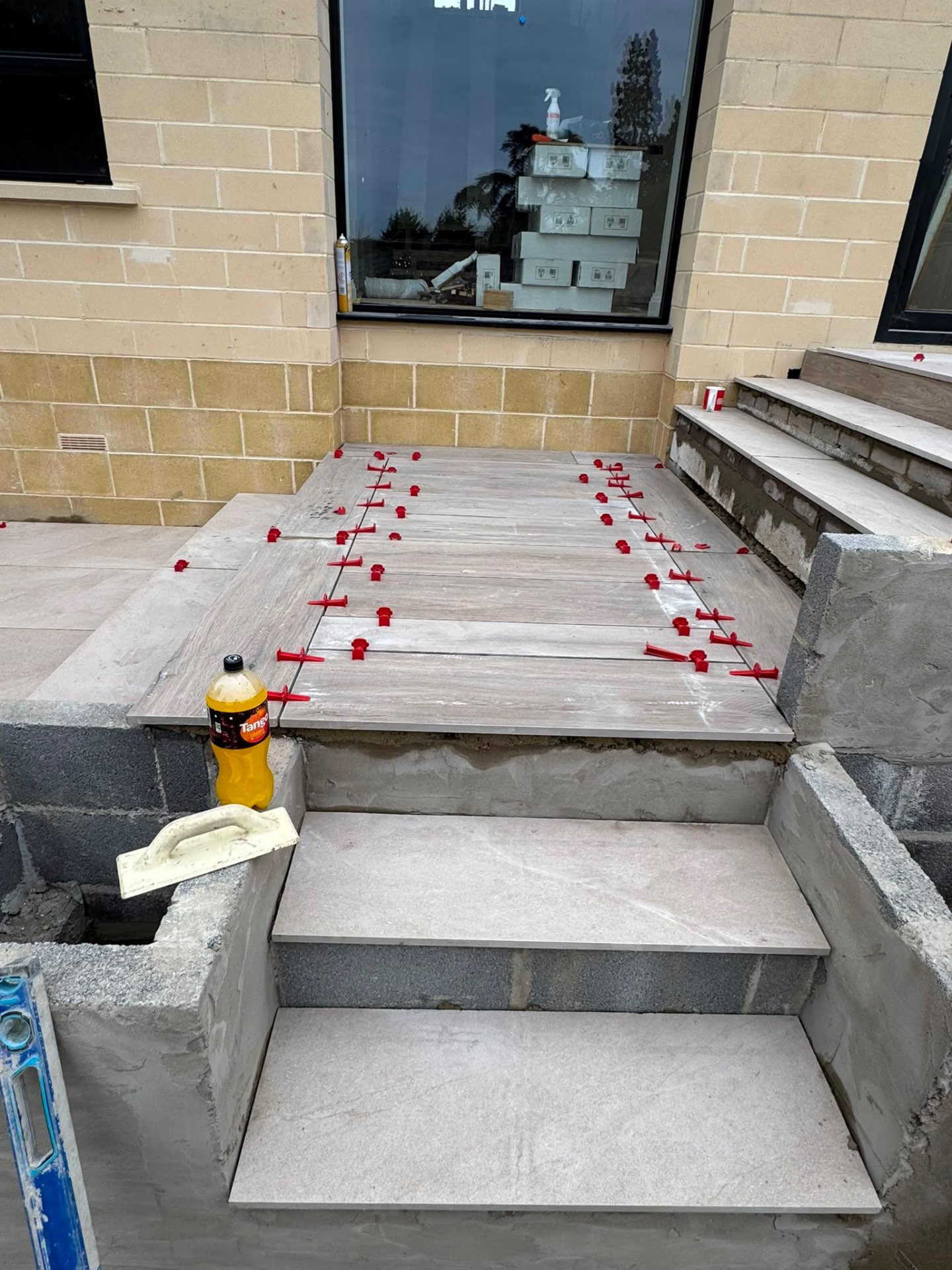 Close view of porcelain step treads and landing being set out in Gloucester with levelling clips