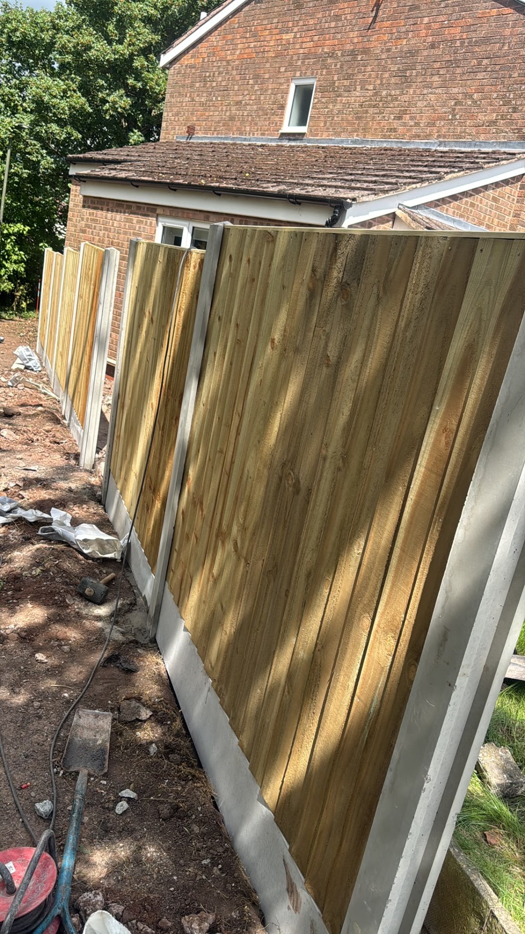 Closeboard fence panels in concrete slotted posts alongside a brick extension in Gloucester