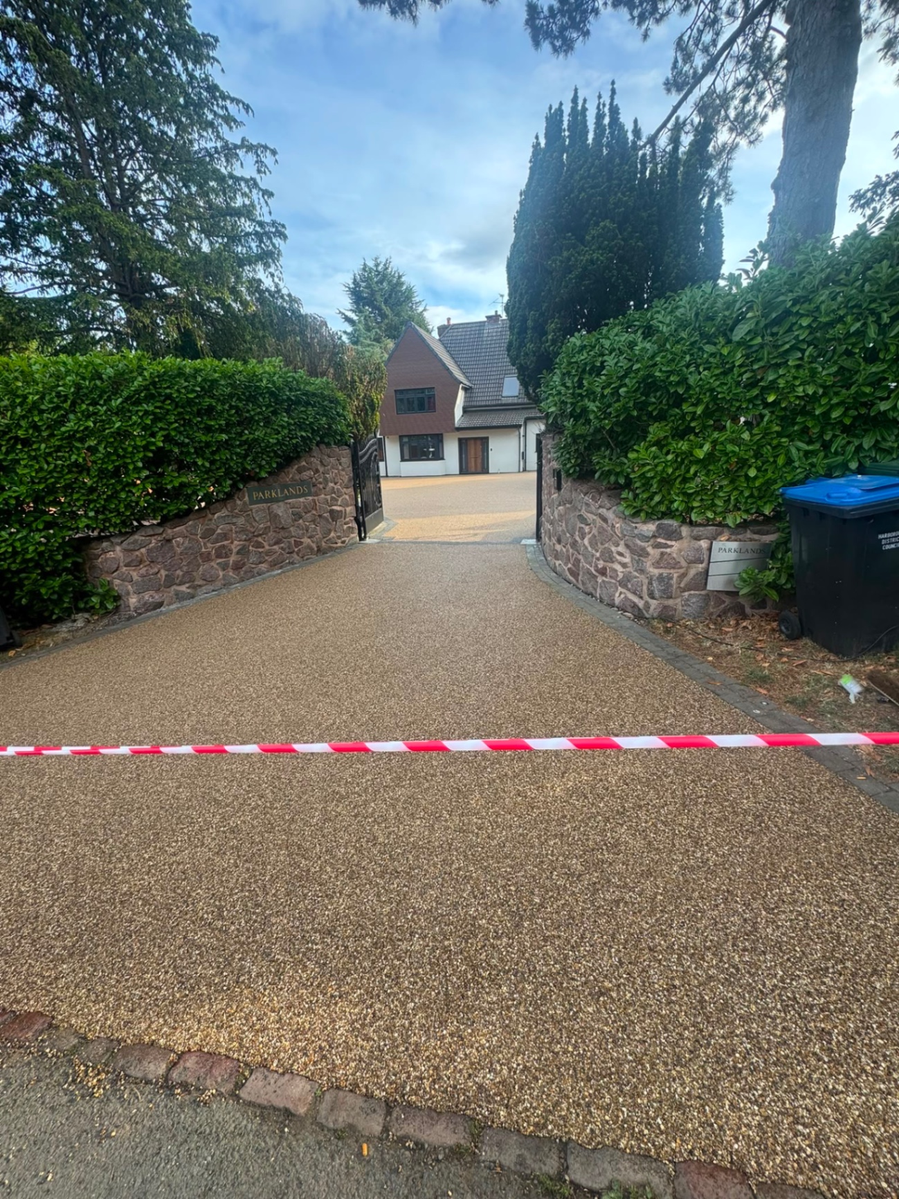 Resin bound driveway entrance apron running from the kerb through stone gate piers in Gloucester