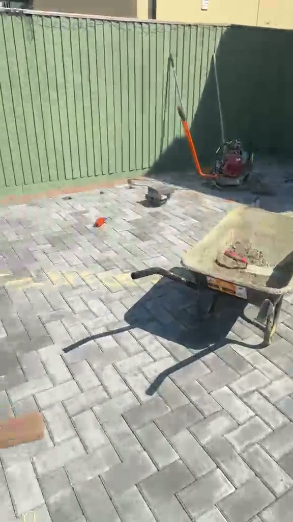 Kiln dried sand and a plate compactor on a finished grey herringbone block driveway in Gloucester