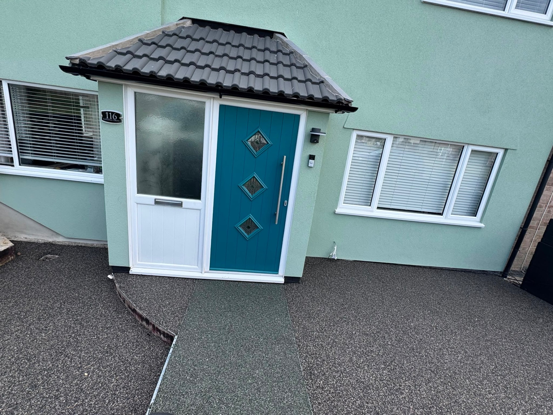 Charcoal resin bound driveway with contrasting path strip at a porch threshold in Gloucester