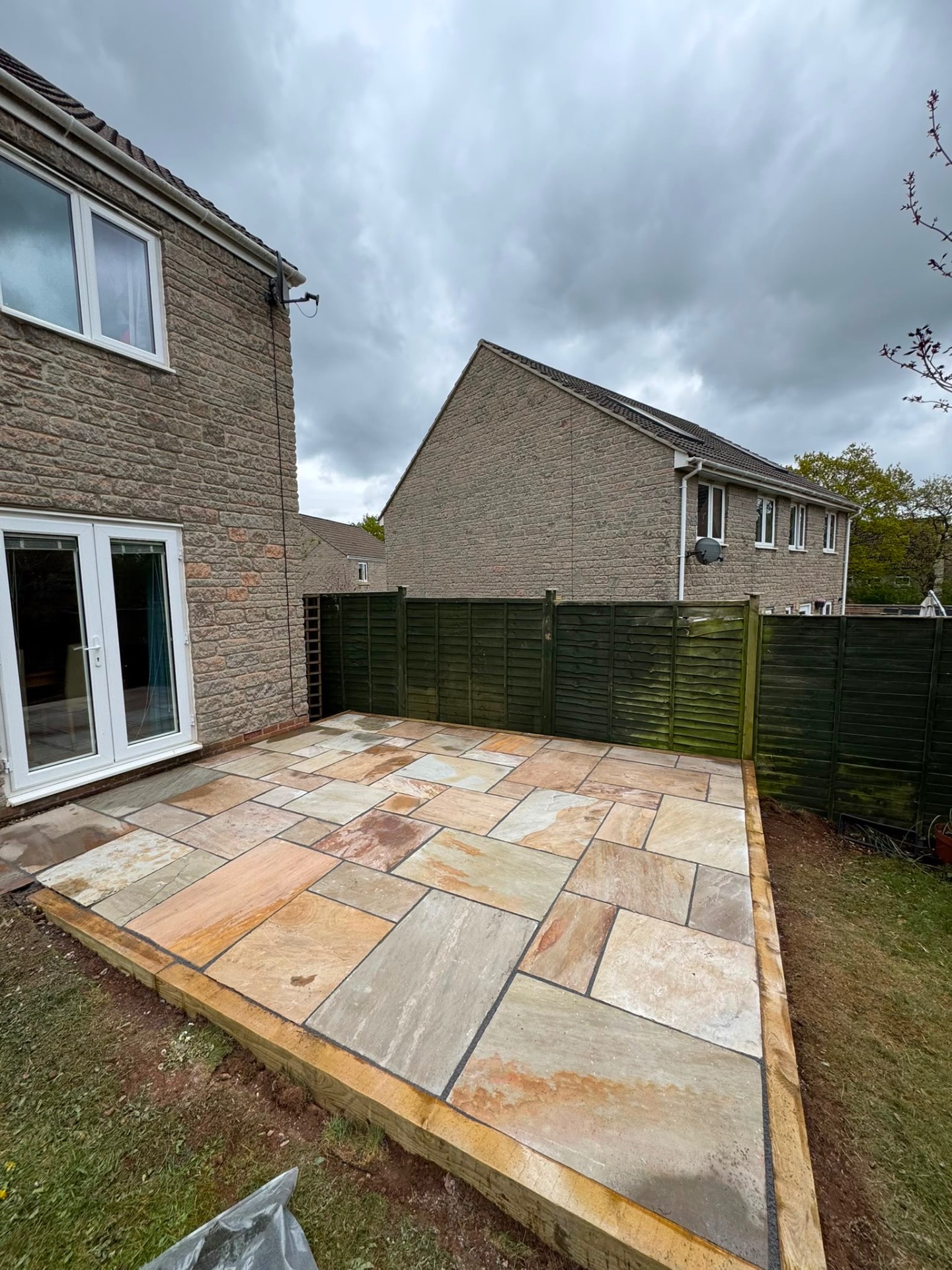 Rectangular Indian sandstone patio in mixed sizes with sleeper edging in a Gloucester rear garden